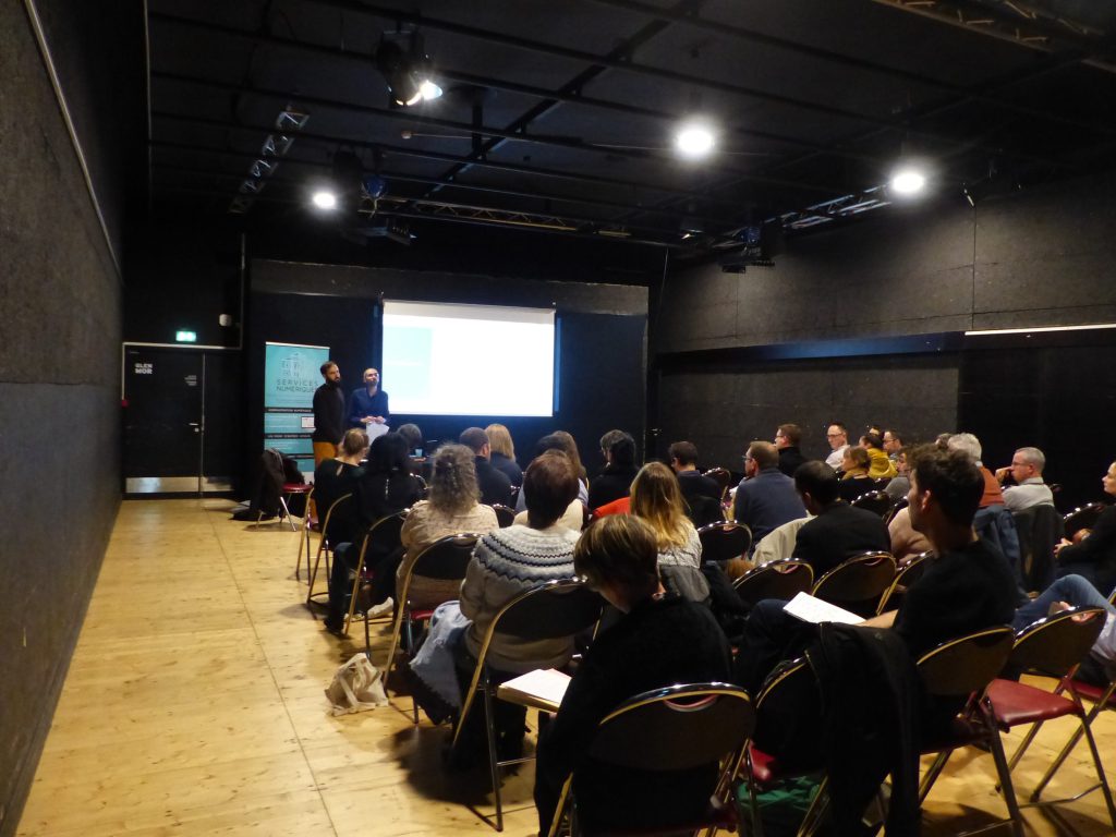 Conférence Services numériques à l'Espace Glenmor avec intervenants, écran et public assis